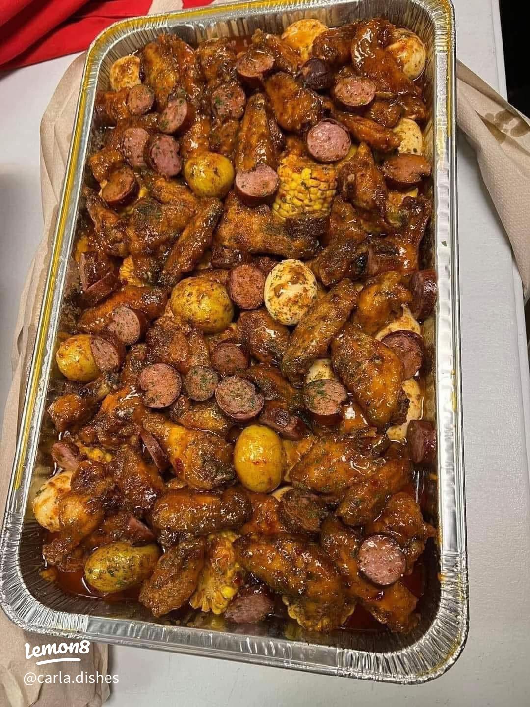 Crabby Mama's Wing Boil — a full pan of Cajun butter wings, smoked sausage, corn, red potatoes and boiled eggs